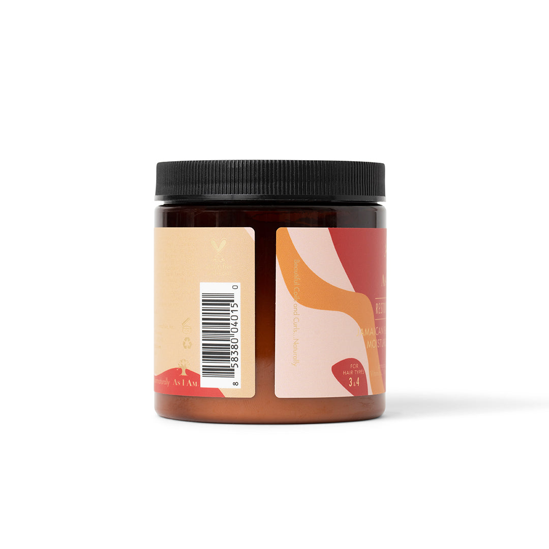The side of a dark jar of As I Am Jamaican Black Castor Oil Moisturizing Masque (227g) with a pink and beige label showing a barcode and some product information.