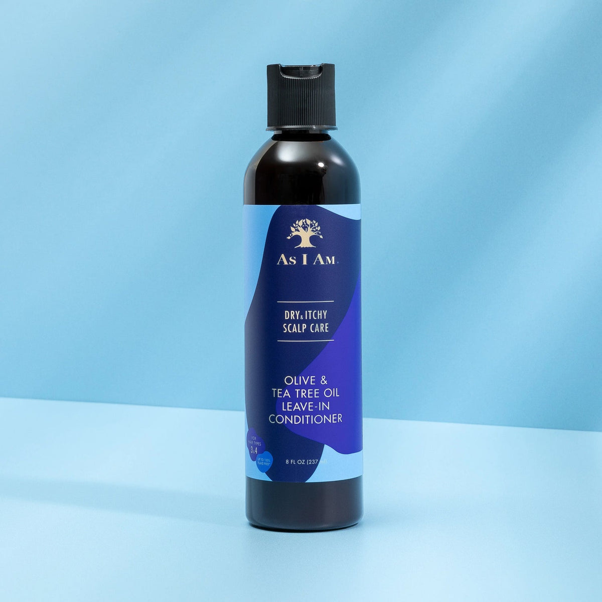 A bottle of As I Am Dry & Itchy Scalp Care Leave-in Conditioner with a blue label that clearly shows the product name and highlights olive and tea tree oil.