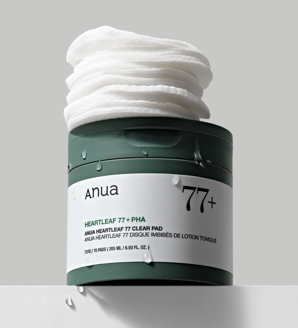 Anua Heartleaf 77 Clear Pad in green container with lid open and stacks of toner-soaked pads on top.