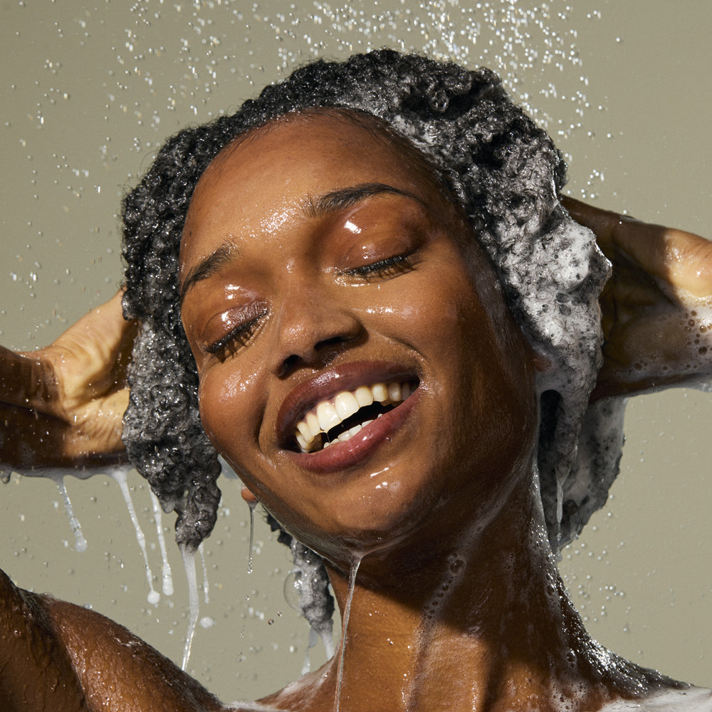 Woman using as i am rosemary shampoo.