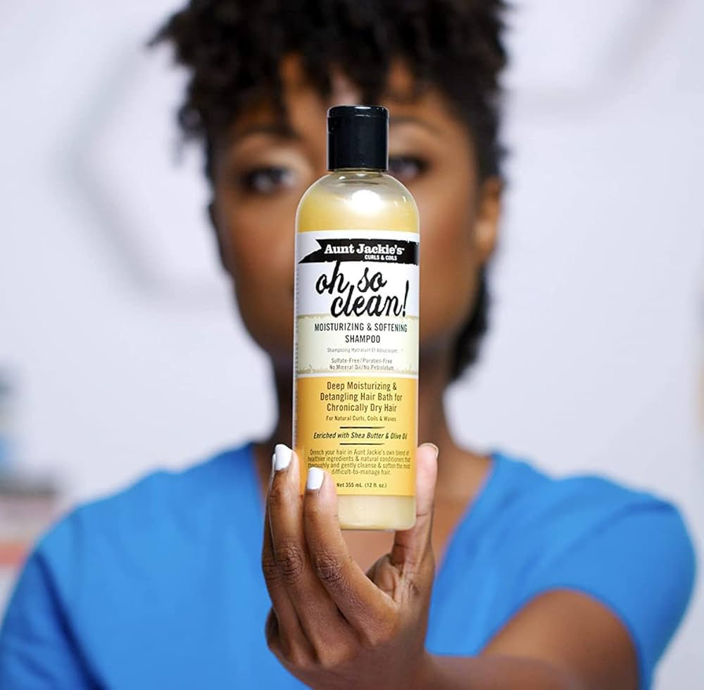 Close-up of a woman holding Aunt Jackie's Curls & Coils Oh So Clean Moisturizing & Softening Shampoo.