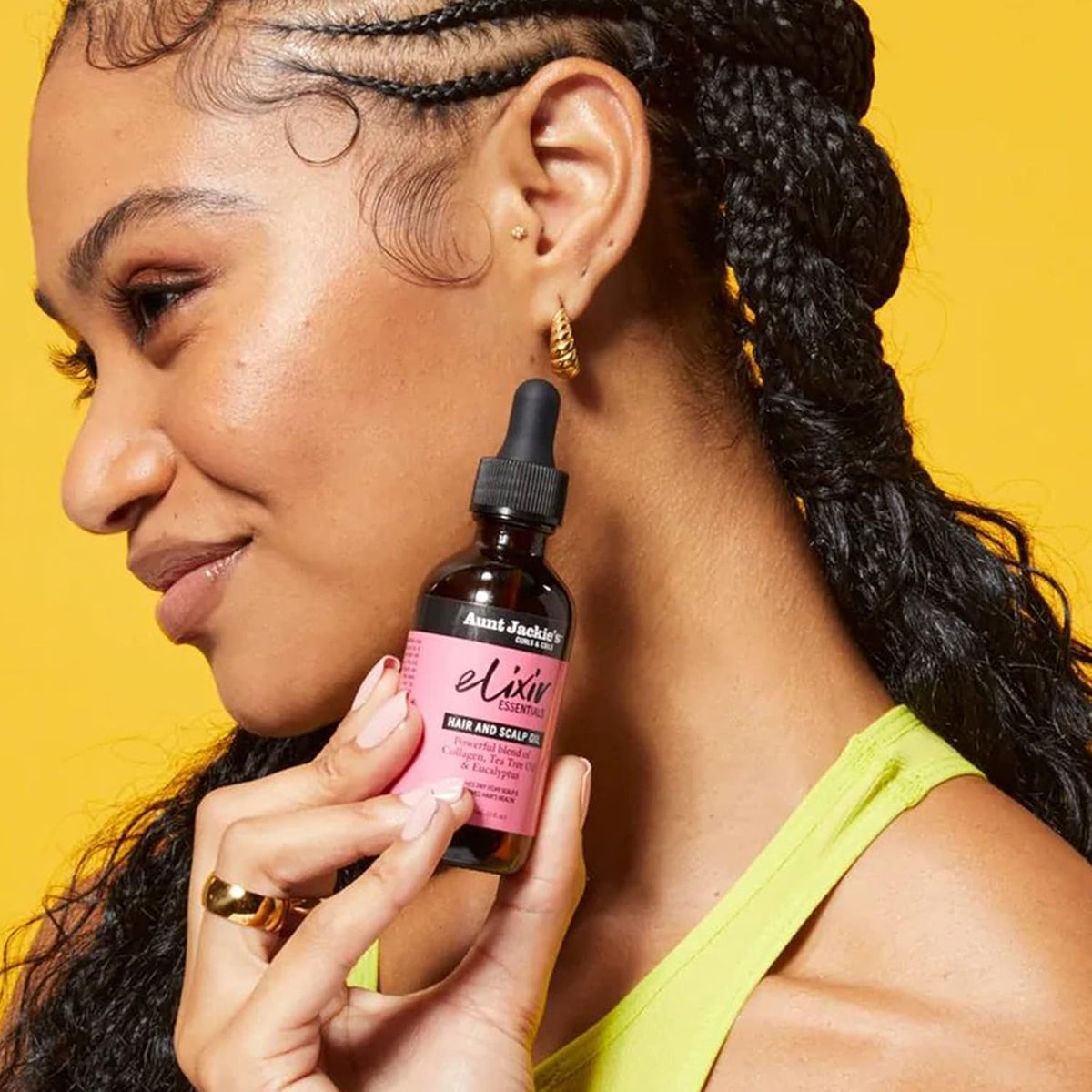 Women holding a bottle of Aunt Jackie's Elixir Hair and Scalp Oil.