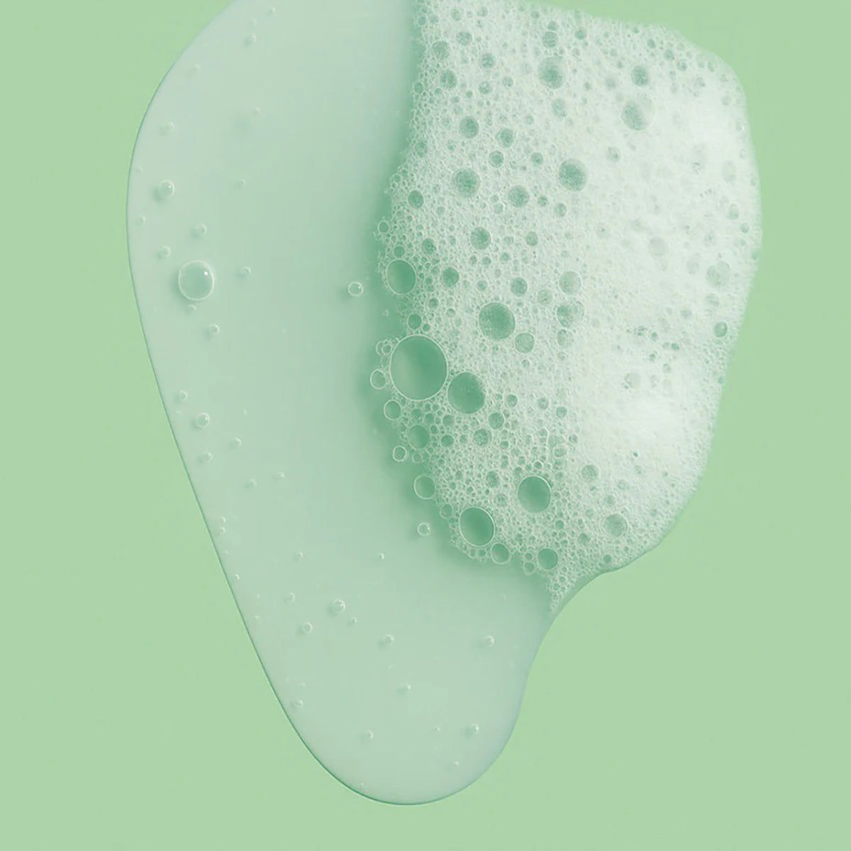 Lightly foaming facial cleanser in liquid form with a mild consistency on a light green background.