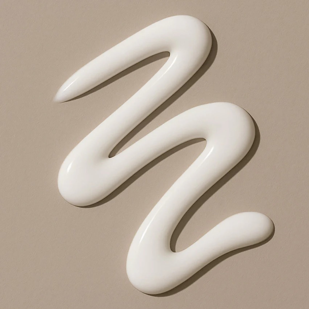 Light, creamy texture of Bali Gents Energizing Face Cream 50ml swirl on a beige background.