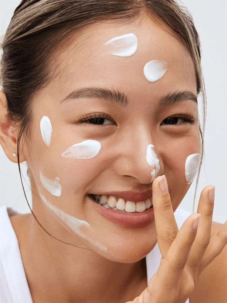 Smiling woman with sunscreen on her face applies Beauty of Joseon Relief Sun Aqua-Fresh: Rice + B5 SPF50+ PA++++ 50ml.