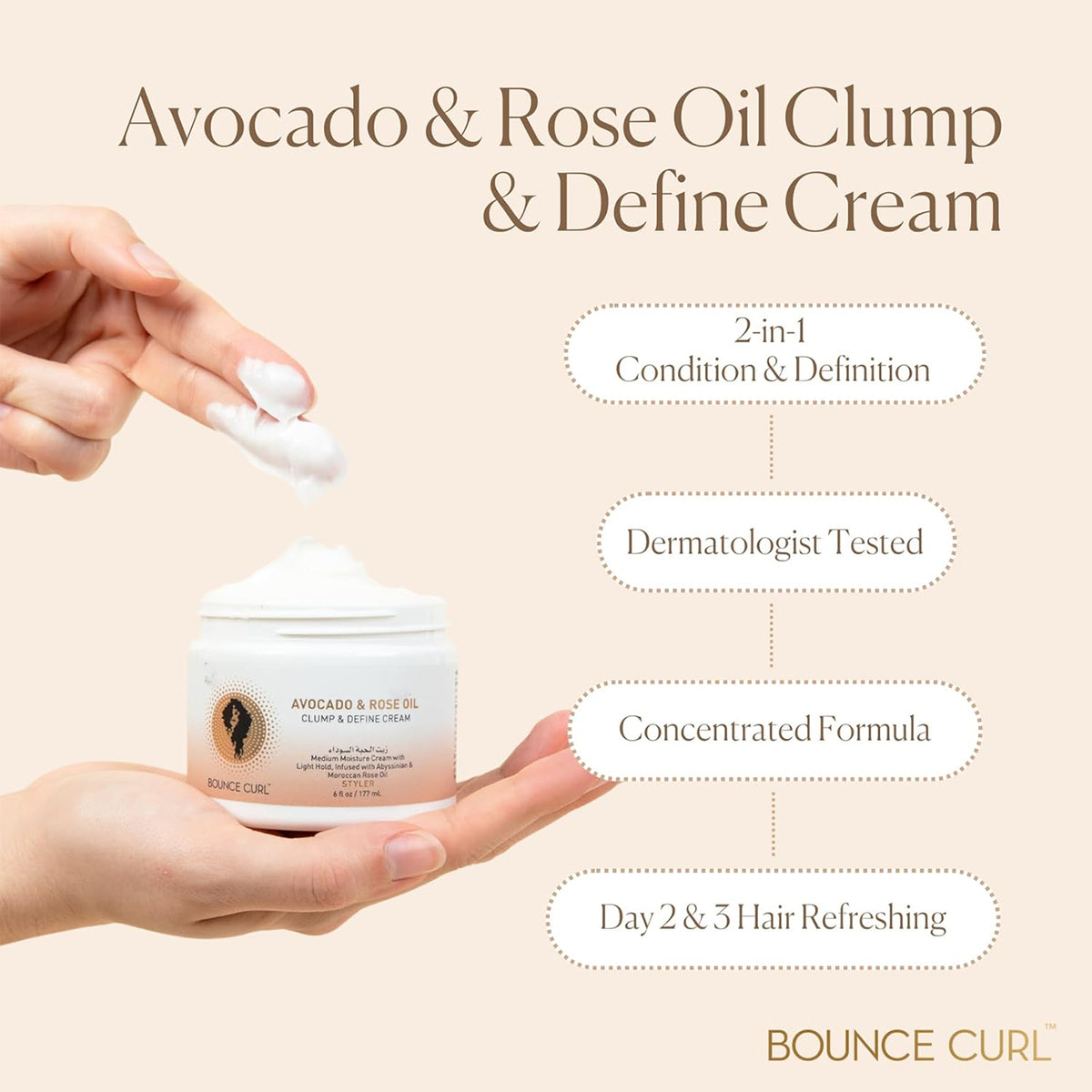 Hand holding Bounce Curl Avocado & Rose Oil Clump and Define Cream 177ml with cream between fingers against beige background.