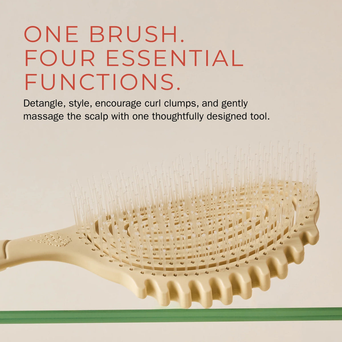 Beige hair brush with bent teeth and fine spikes for detangling, styling and scalp massage of curls.
