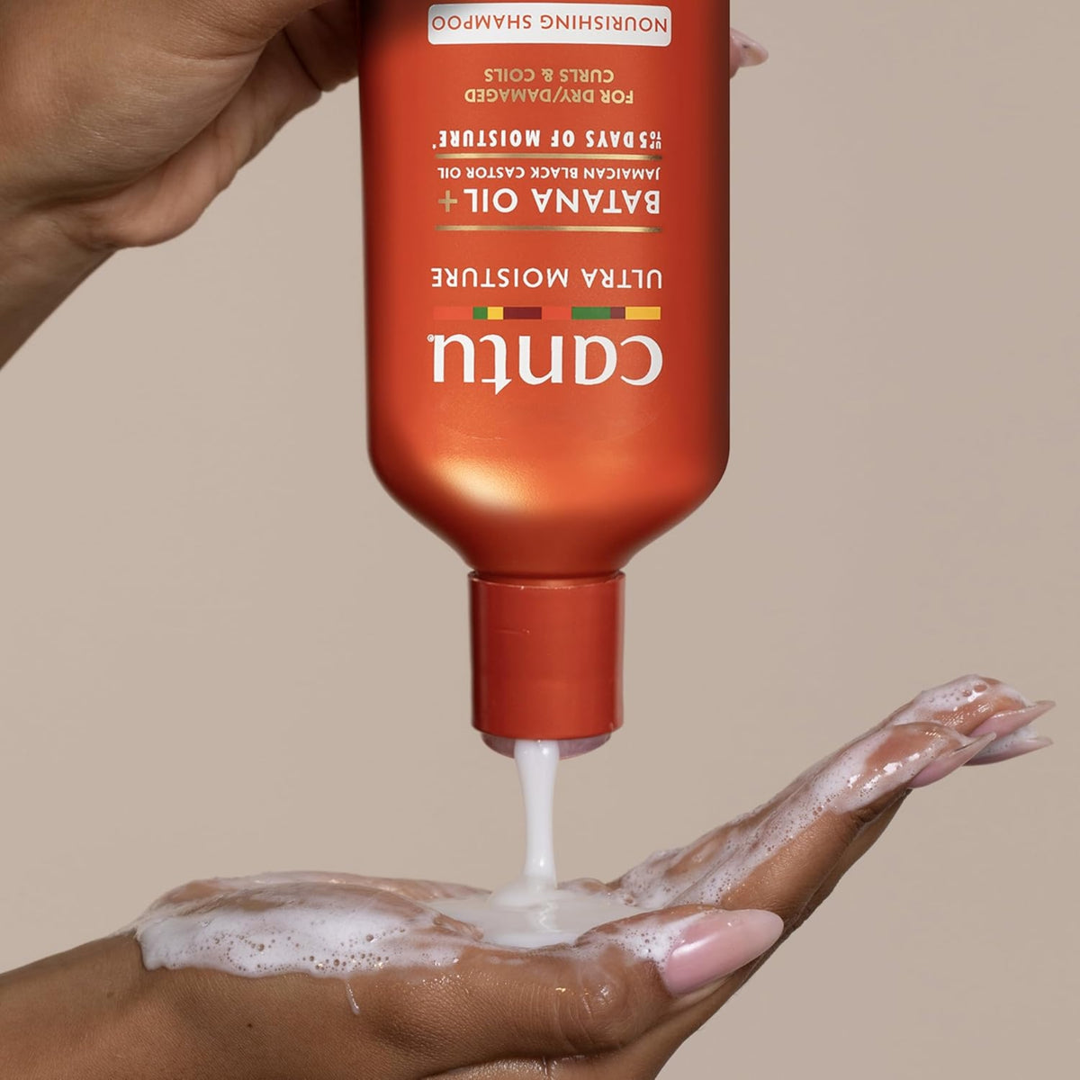 Cantu Ultra Moisture Nourishing Shampoo with Batana Oil is poured foamingly into the hand.