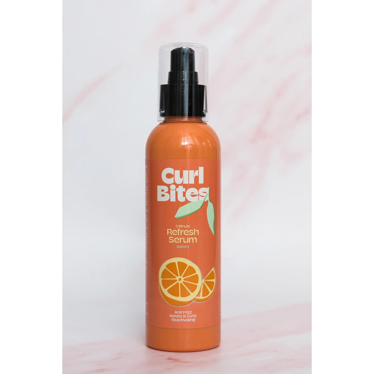 Curl Bites 2 Minute Refresh Serum, orange bottle with black pump and orange motif on light marble background.
