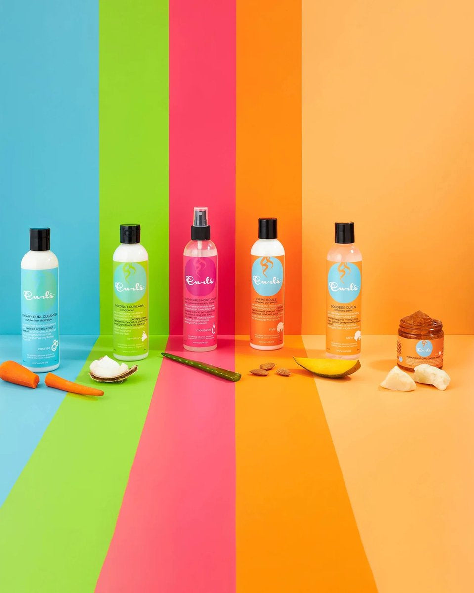 Product range from Curls with colorful backgrounds and natural ingredients. Includes Curls Coconut Curlada Conditioner (white bottle with green label), and other products with white bottles and different color labels (pink, orange, light blue). 