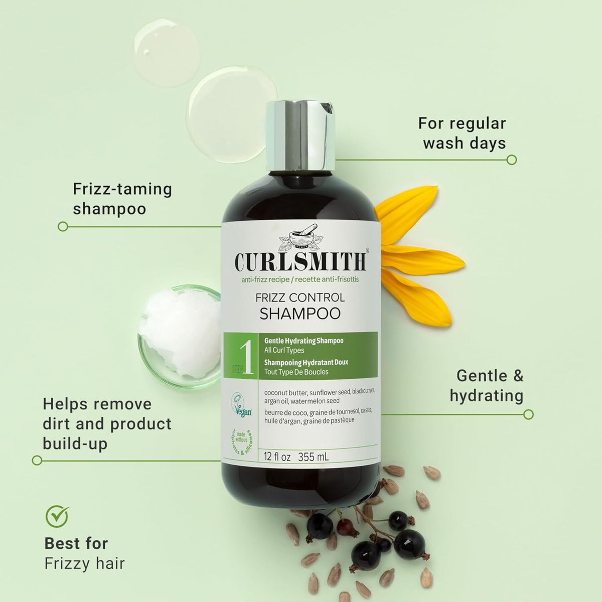 Curlsmith Frizz Control Shampoo, dark bottle with green label, surrounded by coconut oil, sunflower flower and blackcurrant.