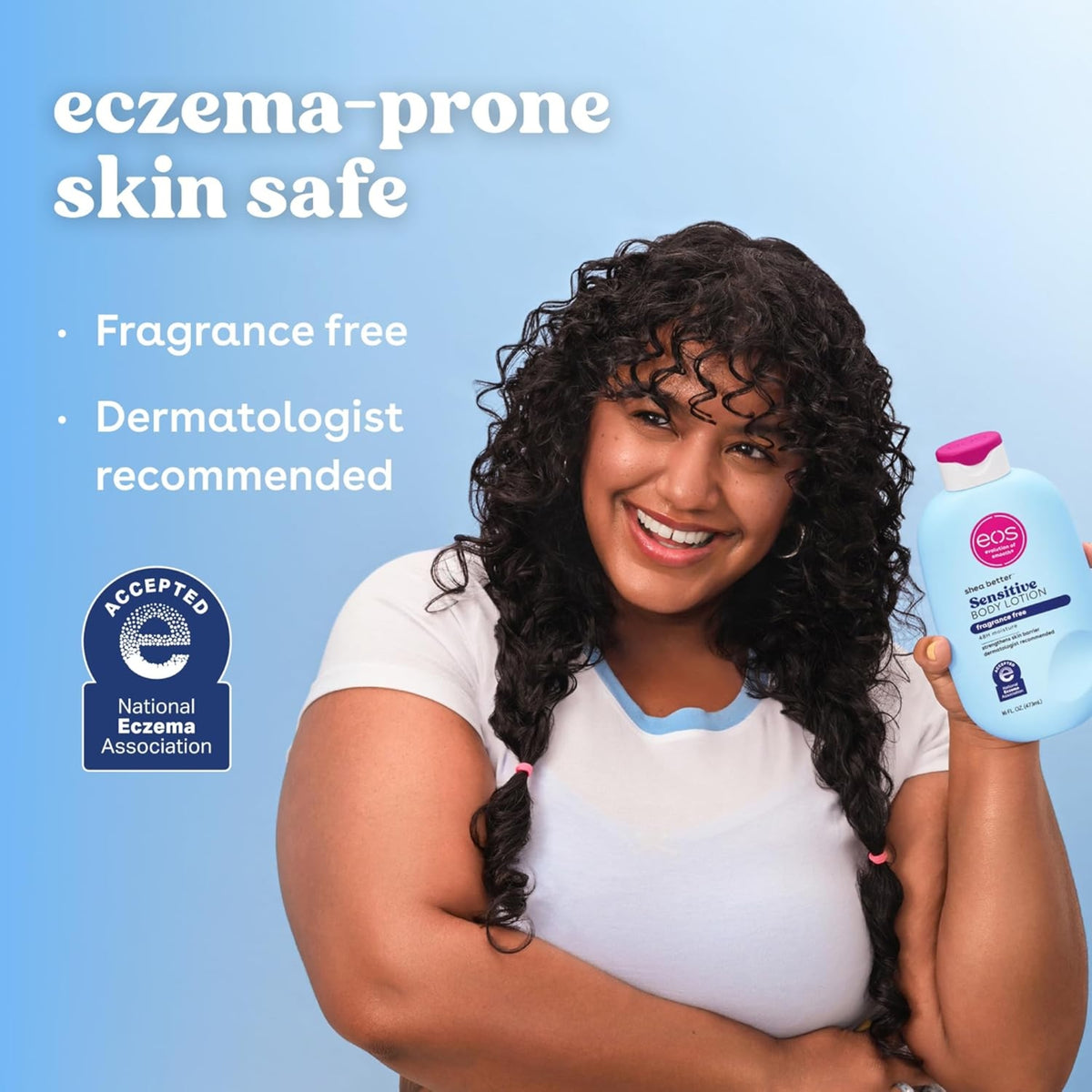 Woman with curly hair smiles and holds eos Shea Better Sensitive Body Lotion, eczema-prone skin safe, fragrance free.