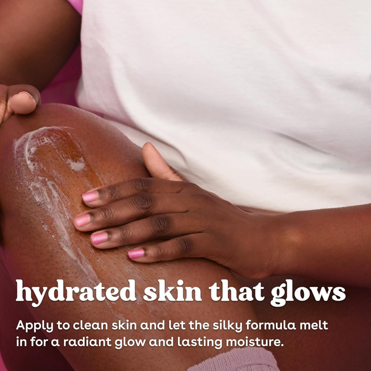Hand with pink nails massaging cream into skin on thigh for hydrated, glowing skin.