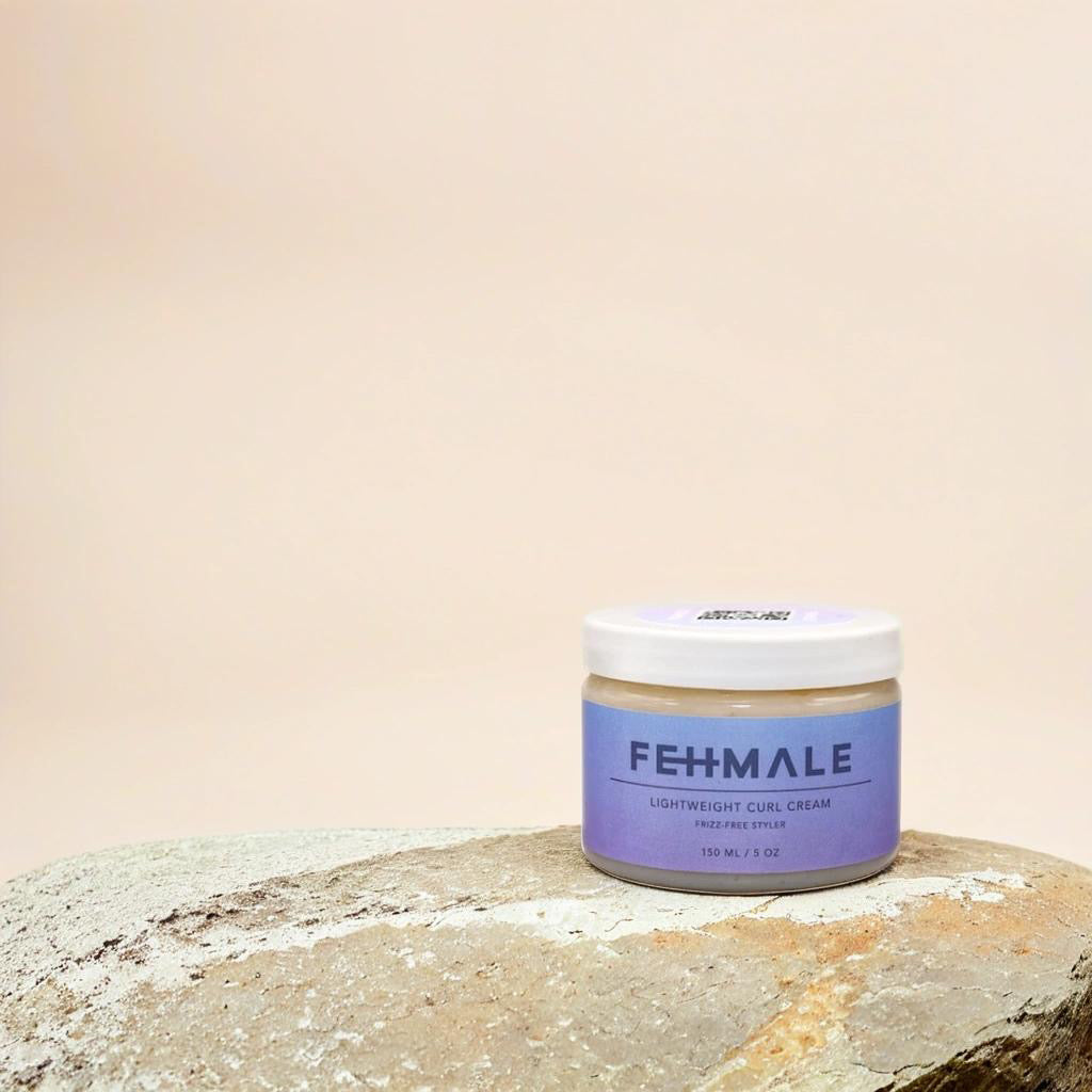 Fehmale Lightweight Curl Cream 150ml in container with purple label, placed on natural stone against beige background.