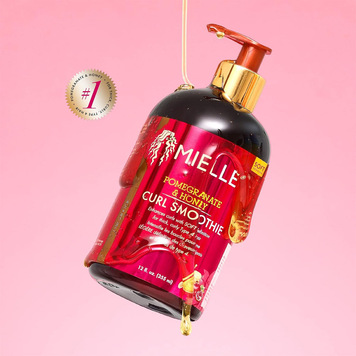 Mielle Pomegranate & Honey Curl Smoothie (355ml) with gold pump and pink label on pink background with dripping product.