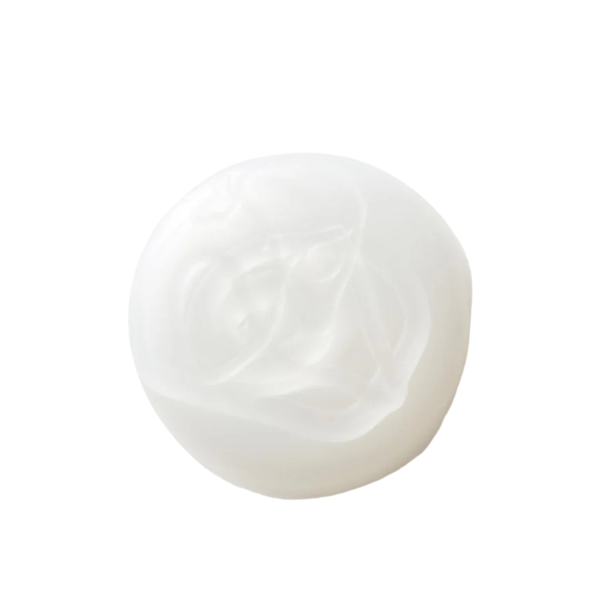 White, round cream or soap bar with a soft, shiny surface and swirl pattern on a white background.