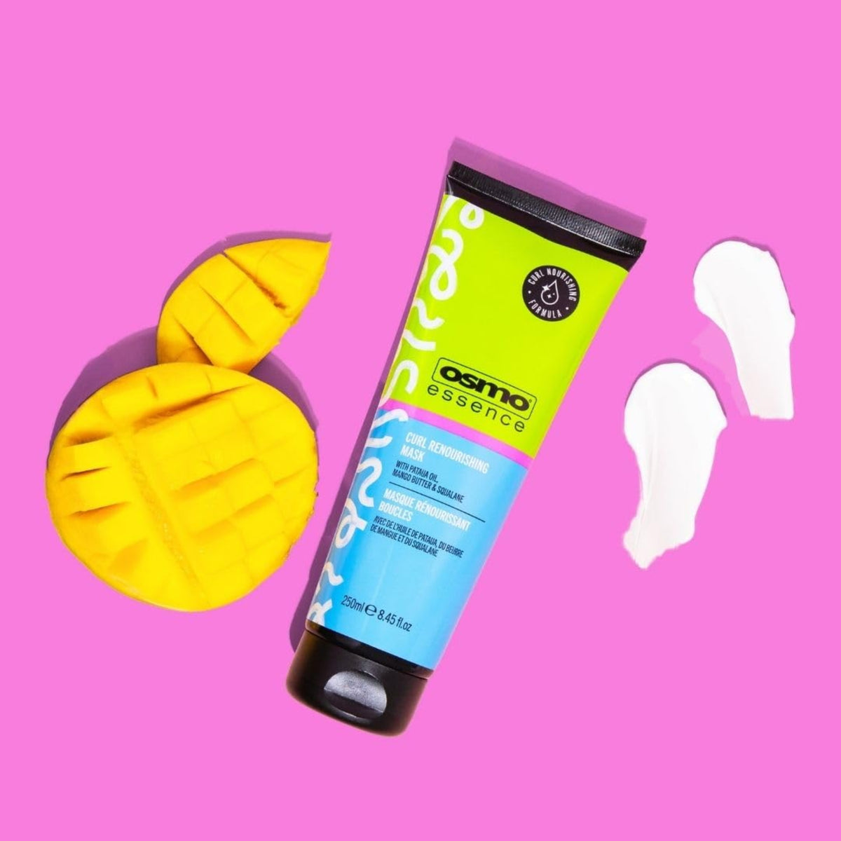 OSMO Essence Curl Renourishing Mask tube on pink background with sliced ​​mango and creamy texture strokes.