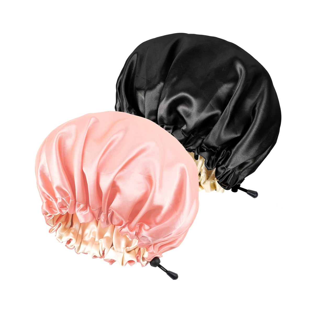 Two silky hair bonnets in black and light pink with adjustable drawstring for hair care at night.