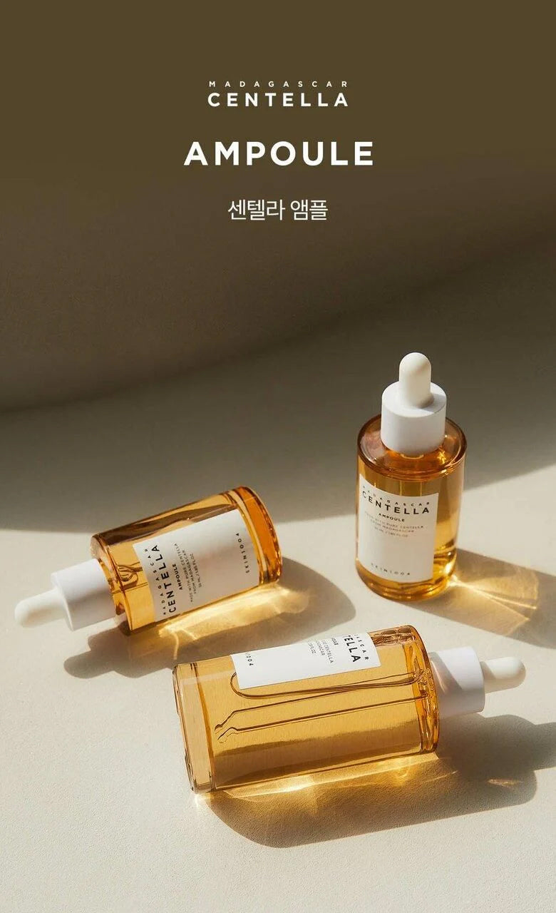 Three bottles of SKIN1004 Madagascar Centella Ampoule 55ml with golden serum on light surface in sunlight.