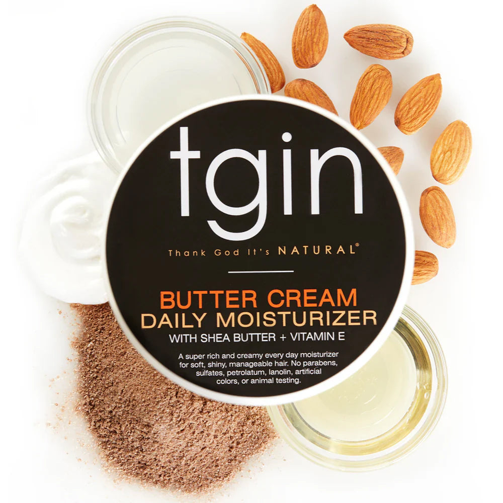 TGIN Butter Cream Daily Moisturizer 340gr with shea butter and vitamin E surrounded by almonds, oil and cocoa powder.